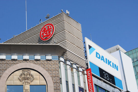 TOKYO, JAPAN - August 19, 2026: Top of Mitsukoshi Department store in Ginza with a Daikin sign displaying the temperature on a hot day next to it.
