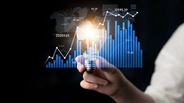 Visualize the fusion of creativity and data in this stock photo, featuring a hand holding a light bulb with vibrant charts and graphs illustrating financial growth. Scalp