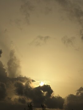 Golden sunlight breaking through dramatic tropical clouds