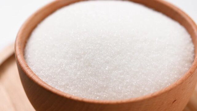 Wooden bowl of white sugar. Close up