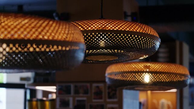 Woven bamboo pendant lamps hanging in cozy coffee shop interior setting.