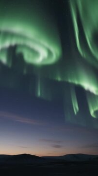 Aurora Borealis Shimmering and Flowing Across a Dark Night Sky with Stars and a Distant Mountain Range. Dynamic Time-Lapse Footage.