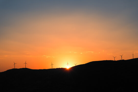 Sun setting behind some wind turbines on the hills above the village of Arnedillo in northern Spain