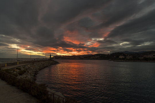 Colorful sunset with cityscape silhouette. Imperia, Italy
