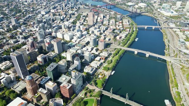 Aerial view of downtown Portland Oregon skyline with Willamette River bridges and urban cityscape during bright sunny summer day.