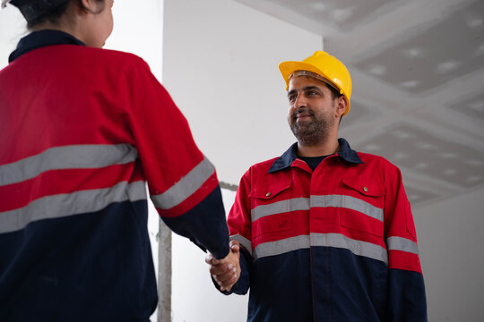 Construction engineers shaking hands during a building project, successful collaboration, contractor partnership, workplace safety, project management, trust, quality assurance, professional teamwork.