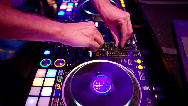 Professional disc jockey mixing music tracks using electronic digital sound equipment at music performance.
