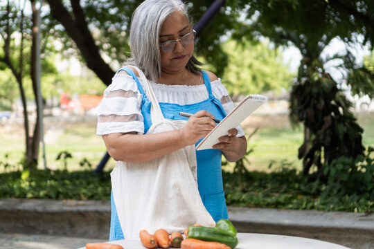 Senior woman planning healthy shopping list outdoors