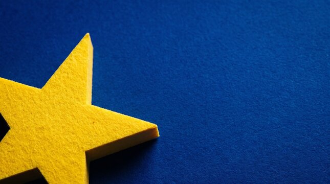 Bright yellow star shape on textured deep blue background for graphic design banner and copy space
