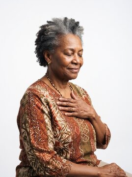 Elderly African American woman with eyes closed and hand on chest expressing peace and gratitude