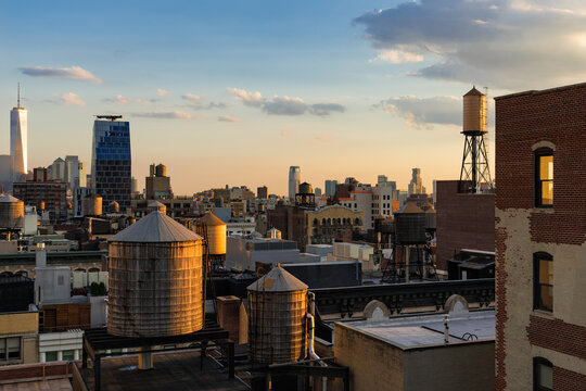 New York City elevated view of traditional water towers and rooftops in the Chelsea neighborhood of Manhattan at sunset, USA
