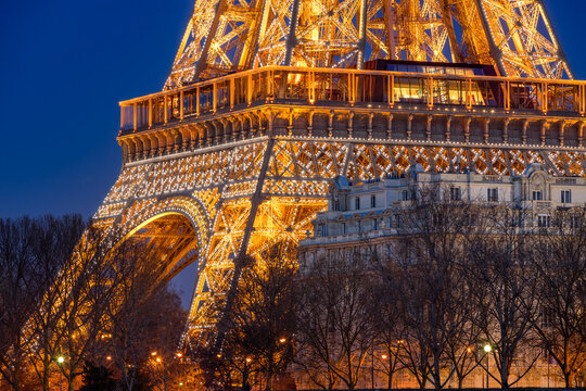 Paris, France - February 29, 2016: Close-up view of the illuminated Eiffel Tower at dusk near Champ de Mars in Paris, France