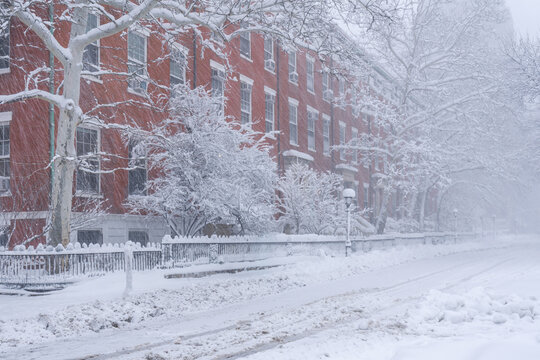 Snow-covered row of historic townhouses in Greenwich Village near Washington Square Park during a winter snowstorm in Manhattan, New York City, USA
