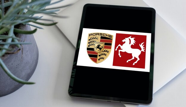 Porsche logo displayed on tablet screen for automotive brand editorial content.