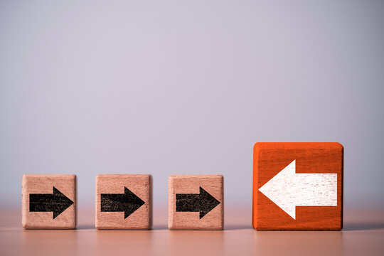 Conflict and disruption concept with one opposite arrow confronting a group moving forward, representing resistance, disagreement, opposition, strategic conflict and business disruption.