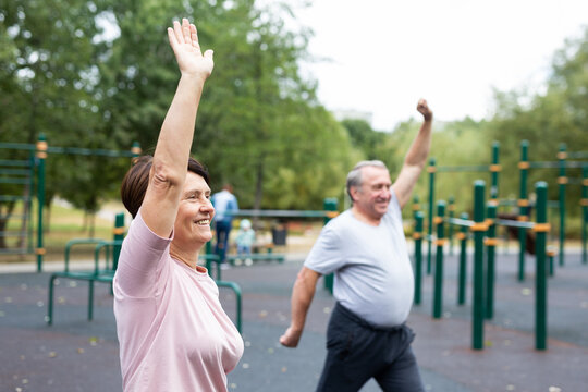 Sports pensioners do a warm-up on outdoor sports ground