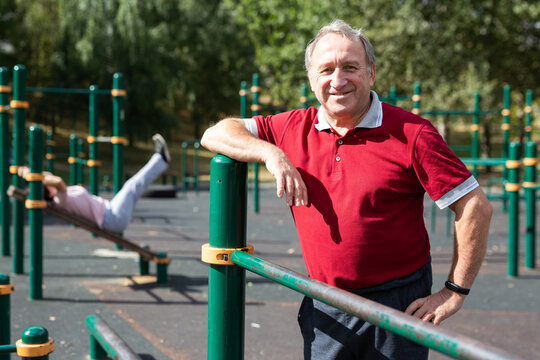 Portrait of an elderly man in sportswear on a sports ground in city park