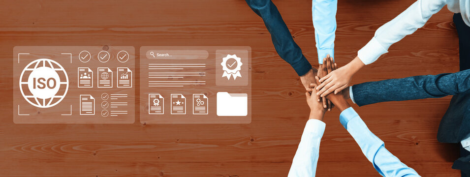 A group of diverse professionals collaborates in an office setting, focusing on quality management standards and ISO certification processes through digital interfaces. Gantry