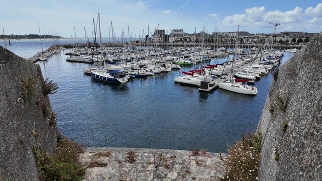 CONCARNEAU, FRANCE &ndash; August 20, 2026: Sailboat marina framed by the historic stone walls of Ville Close, with numerous yachts moored at floating docks in Concarneau, Brittany.
