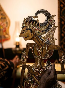 Traditional Javanese Wayang Kulit Shadow Puppet Held by Dalang Puppeteer