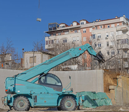 Forklift Telehandler With Forks Attachemnt at Construction Site Sunny Day