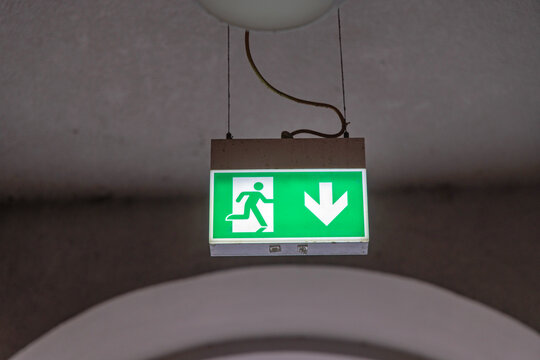Illuminated Emergency Exit Green Sign Glow Hanging From Ceiling Building Safety
