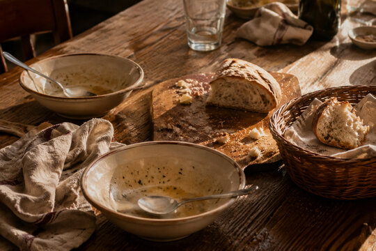 Dinner table with soup bowls and bread remnants, family meal and togetherness concept