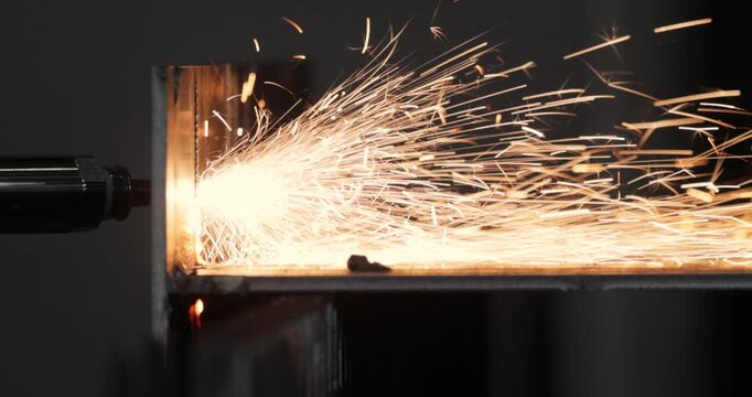 Industrial CNC laser cutting machine with flying sparks in metal fabrication.
