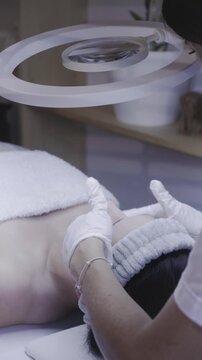 Gloved hands massaging skin during a gentle facial treatment