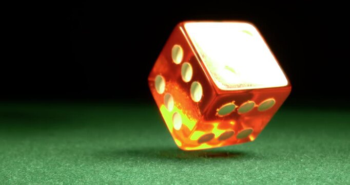 Dice fly and tumble toward the camera in extreme slow motion, landing on a green casino table with