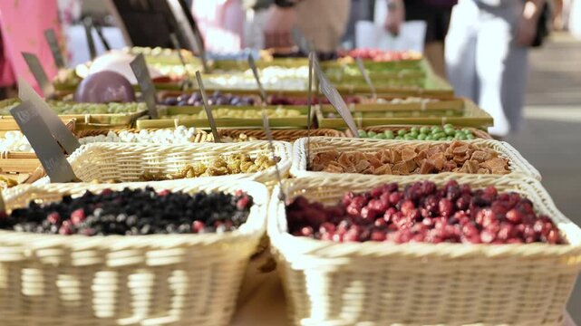 Dried fruits and berries filling wicker baskets at a bustling street market stall