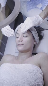 Serene facial massage delivered with gloved precision under ring light