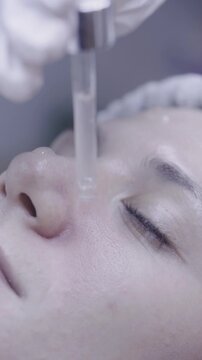 Serum drops applied to closed eyelid in tranquil skincare ritual
