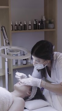 Gloved hands guiding careful facial massage in calm treatment room