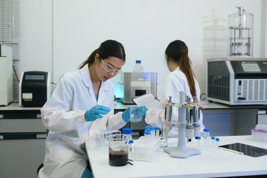 Female Scientists Working in Modern Research Laboratory with Equipment and Chemical Samples