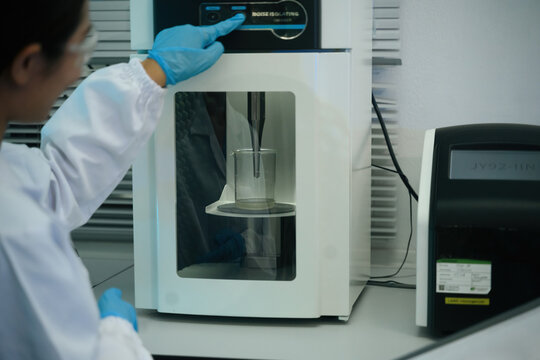 Cropped of Scientist Operating Ultrasonic Homogenizer in Laboratory with Noise Isolating Enclosure