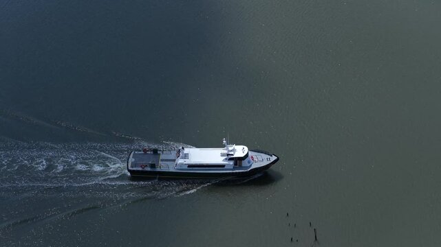 Boat motoring on Cedar Creek on Delaware coastline on peaceful summer day with sunshine and cloud shadows