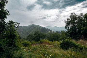 Fototapeta premium Foggy green mountains and forest landscape near Visegrad, Bosnia and Herzegovina, under a cloudy summer sky