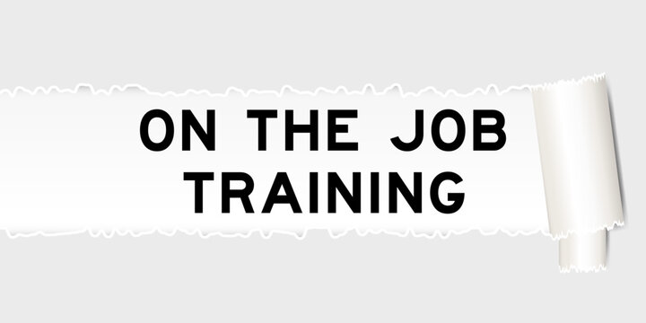 Ripped gray paper background that have word on the job training under torn part