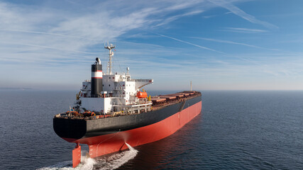 Massive bulk carrier ship Sailing in the Open Ocean, Industrial Freighter for Maritime Shipping, Logistics, Trade, and Transportation © dechevm