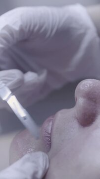 Fine metal tool gliding along lash line in precise facial care