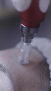 Fine glass applicator resting gently on closed eyelid skin