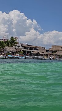 RIO LAGARTOS, YUCATAN, MEXICO &ndash; 5.7.2026: View of the waterfront of Rio Lagartos with traditional boats and local buildings, seen from a boat on the lagoon