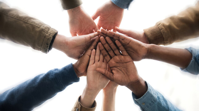 Diverse group of hands stacked together in a team huddle demonstrating unity collaboration and support on a white background