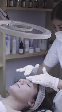 Gentle facial massage performed with gloved hands in calm spa setting