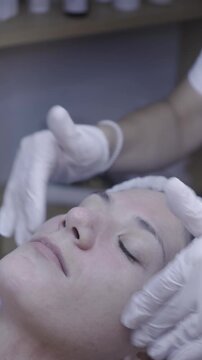 Gloved hands cradle face during soothing spa facial ritual