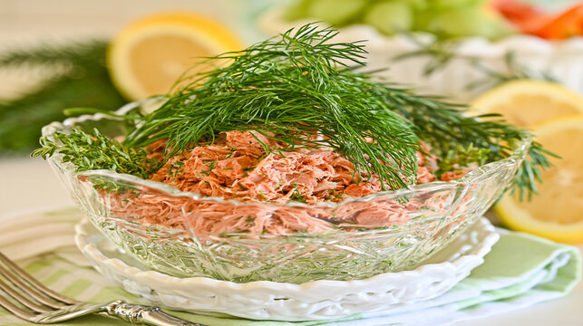 Salmon salad topped with fresh dill served in a crystal bowl fish salad dill topping