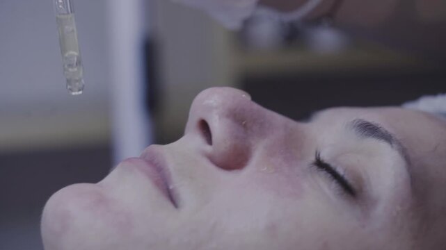 Gloved fingertips pressing gently along the cheek during a calming facial