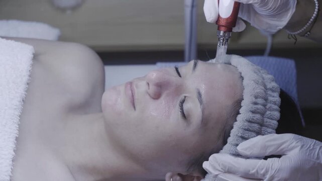 Metal skincare device gliding across the forehead in a tranquil facial