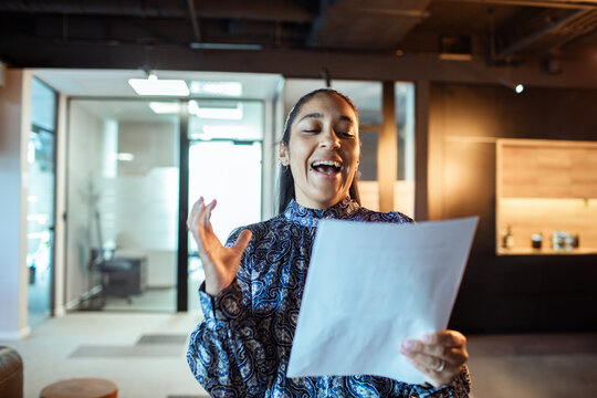 Smiling businesswoman rehearsing presentation in modern office